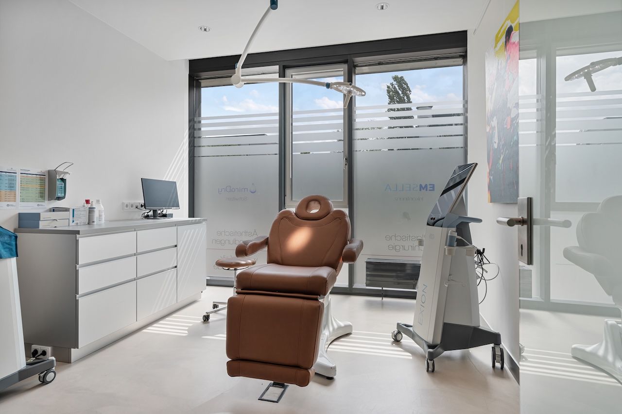 Behandlungsraum für miraDry und Emsella mit Behandlungsstuhl und moderner Gerätetechnik bei Tageslicht